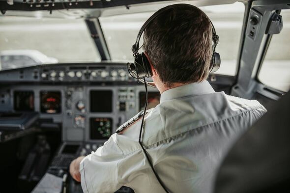 Mature pilot sitting in cockpit stock photo
