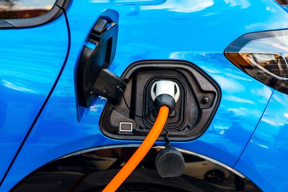 Electric car charging on the street, car plug in the charger close-up