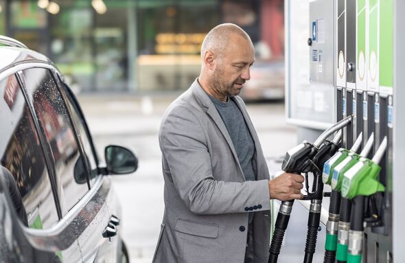 A man is about to refuel his car at a gas station.
