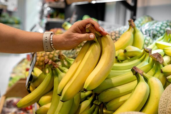 a woman buys fresh bananas at the supermarket