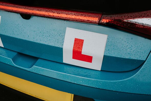 Close-up of an L-plate on the rear of a learner driver’s car in wet weather.
