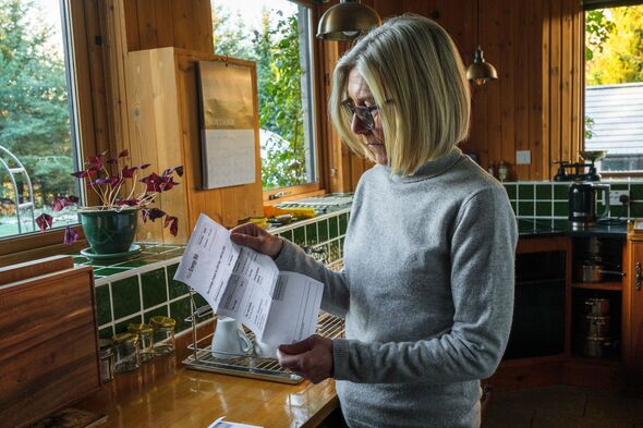 Woman reading her energy bill in kitchen