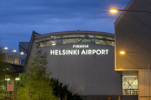 Helsinki-Vantaa Airport, operated by Finavia, terminal 2 exteriors at night. Dark storm clouds in the background.