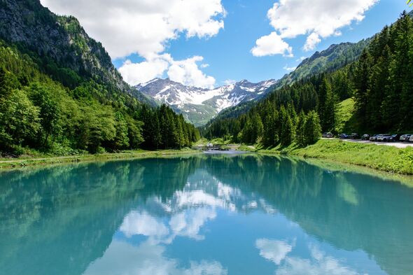 Scenic view of forest and mountains reflected in lake