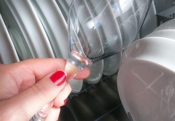 Woman picking up a dishwasher glass