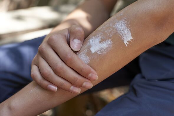 Teenage boy applying sunscreen during hiking day