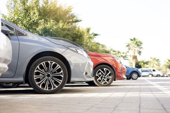 A row of new colorful vehicles on the parking. A line of used cars and trucks for sale