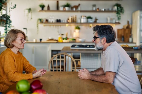 Senior couple having a calm conversation at a kitchen table in a cozy modern home