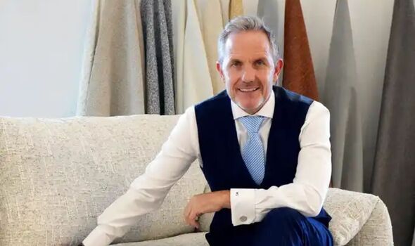 A man sat on a sofa in a suit