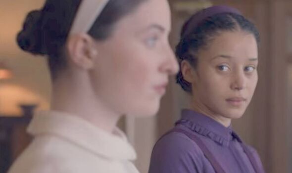 A girl in purple looks at a girl in white