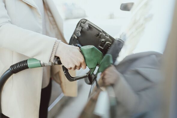 Midsection of woman refueling car at gas station