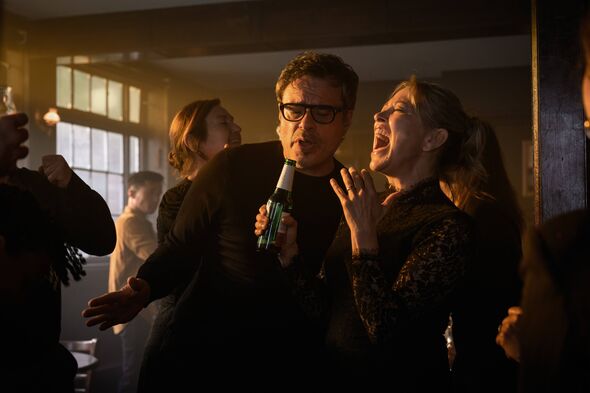 Two people laughing in a busy pub