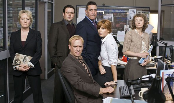 A group of people stand in an office setting