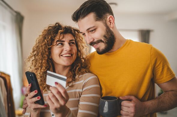 adult happy couple man and woman shopping online hold credit card