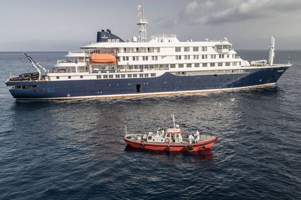 TOPSHOT - An aerial view of an ambulance boat carrying crew members wearing hazmat suits as they approach the pilot door on the