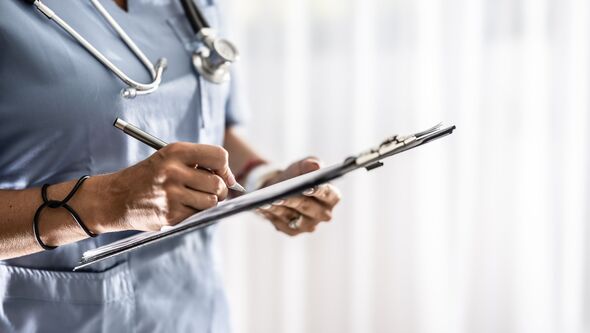 The doctor signs the patient's medical report in the outpatient clinic.