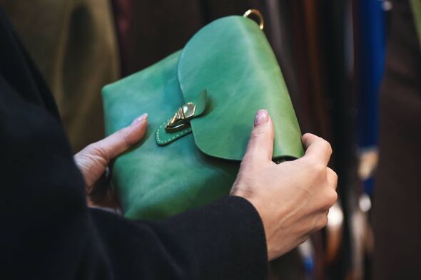 Cropped Female's Hands Holding Green Colored Handmade Leather Bag At The Local Flea Market