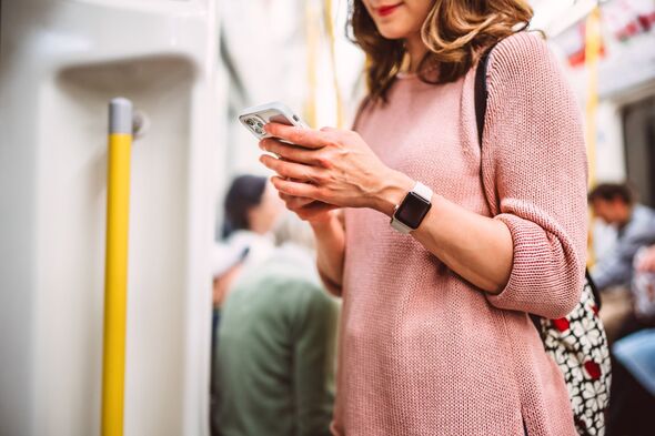 Asian woman using smart phone while commuting on public transit