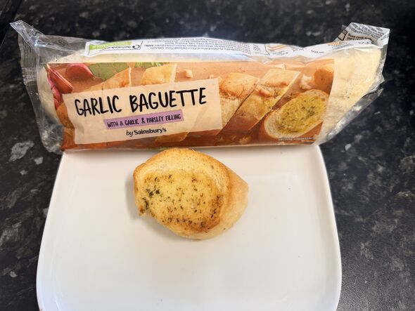 Sainsbury's garlic baguette packet with slice on kitchen counter