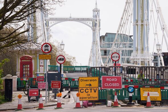The Grade II listed Albert Bridge (1873) which connects Battersea to Chelsea in London covered in road signs after being closed