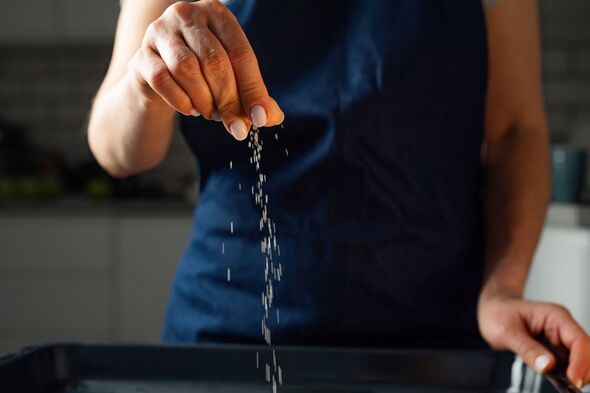 Woman Salts Food With A Pinch Of Salt