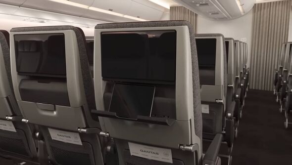 An ipad on a folding shelf attached to a plane seat