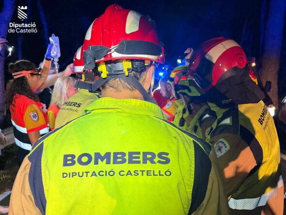 Emergency responders, wearing distinctive helmets and safety gear, are gathered at the scene of an incident, with one individual