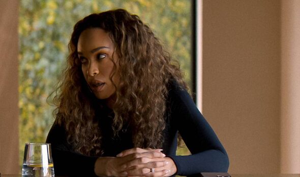 Curly haired woman sitting at a table.
