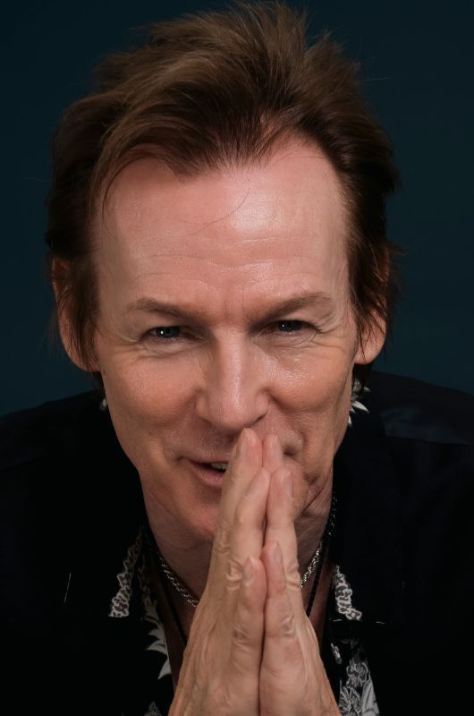 Close up of Mark Shaw smiling with his hands in a prayer gesture in front of his face