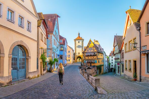 A woman walks through Rothenburg ob der Tauber in the early morning. This beautifully preserved medieval town in Bavaria, German
