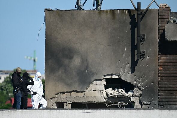 Police and forensic investigators examine the location of impact after a Russian drone struck an apartment in Romania