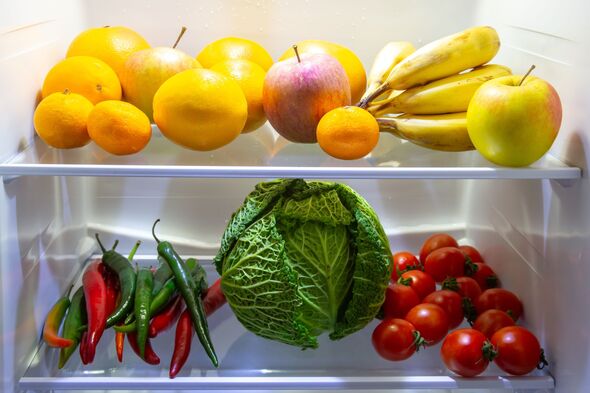 Fresh fruits and vegetables organized in a refrigerator during the day in a kitchen setting