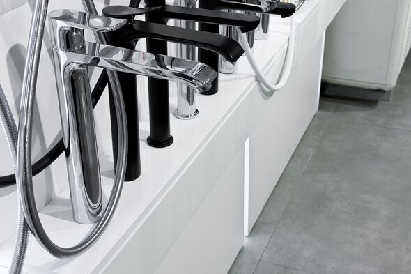 Modern chrome and black plumbing fixtures displayed in a showroom