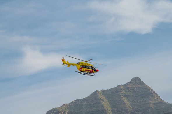 Sanitary copter manouvering with a mountainous landscape as backgound