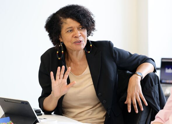Chi Onwurah sitting at desk in front of tablet