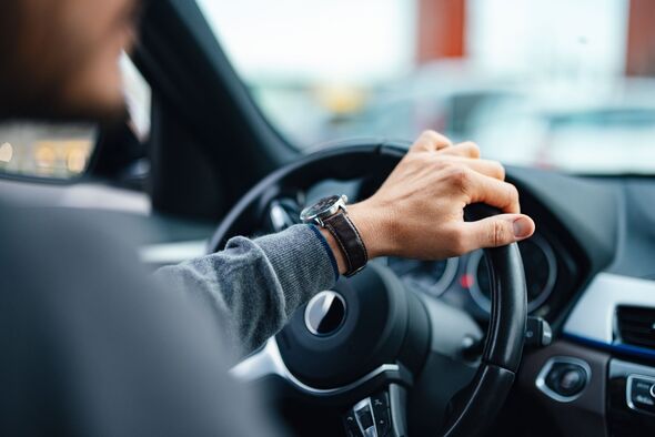 An unrecognisable person driving car