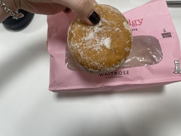 Sugary jam donut held in hand