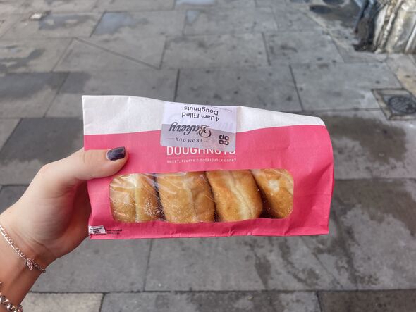 Donuts in pink package against pavement