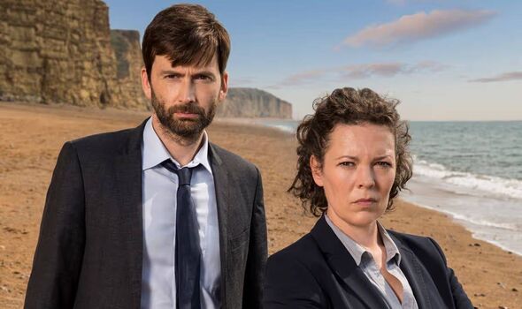 Bearded man and curly haired woman standing on a beach