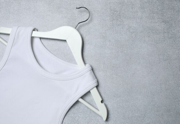 Hanger with a white T-shirt on grey background. Mockup for design