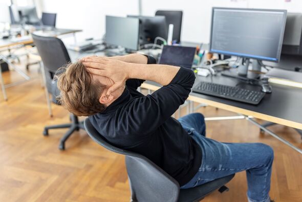 Businessman feeling stressed at desk in startup office