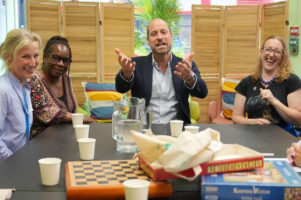 Prince William chats to people during his visit to the charity