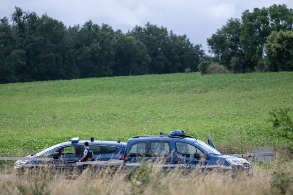French police block the road near a farm silo where a body was found yesterday