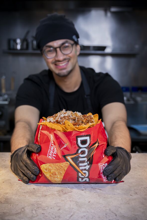 Man holds out a bag of loaded Doritos