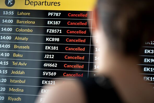 A female passenger checks her flight status on the airport arrivals and departures board in Krakow, Poland, on March 5, 2026. Th