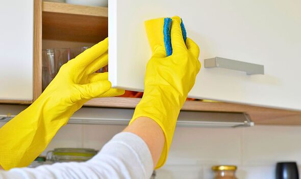 Picture of someone cleaning kitchen cabinets