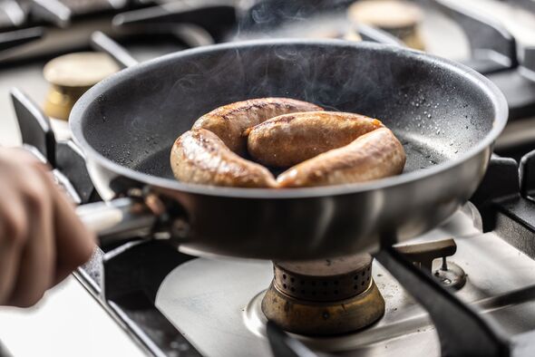 Sausages are cooked in a pan in the restaurant's commercial kitchen.