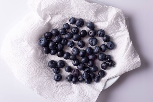 a handful of blueberries on a white napkin in a plate.