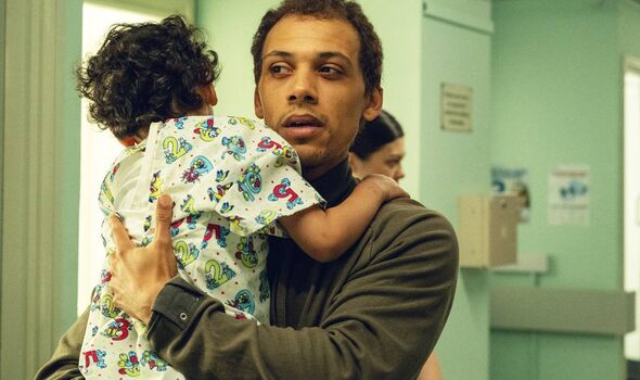 Young man carrying a toddler in a hospital
