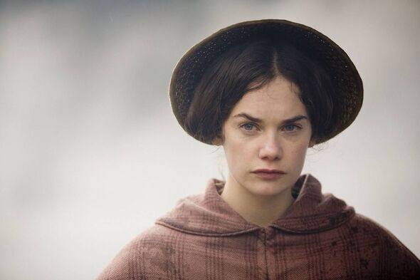 An individual dressed in traditional attire, donning a broad-brimmed hat, and displaying a contemplative expression.